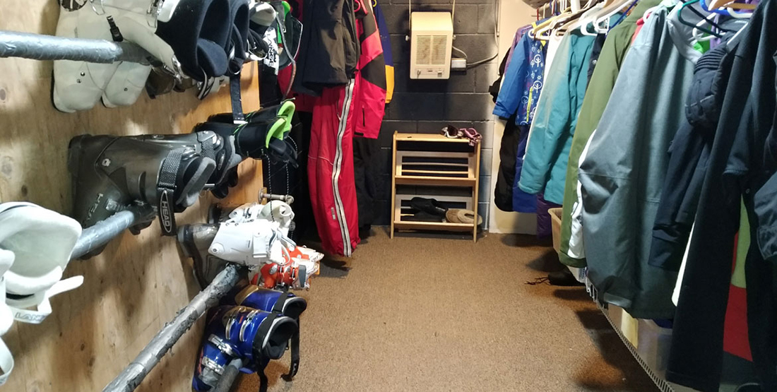Room with ski boots and jackets hanging up on the walls