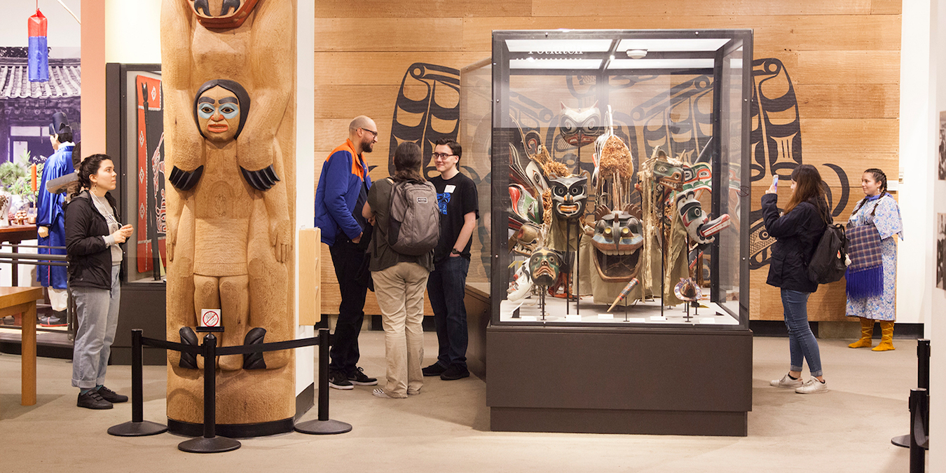 People inside of a museum exhibit surrounded by native art