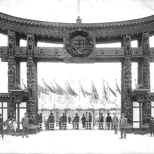 black and white photograph of the entrance to AYP with totem poles lining its sides