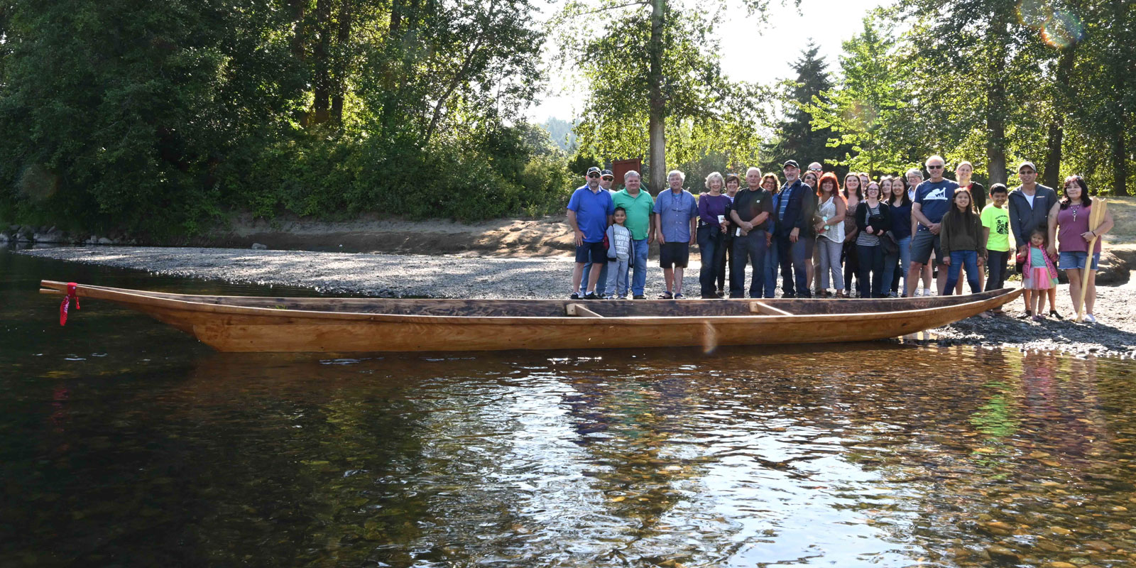 a group of people stand next to the canoe