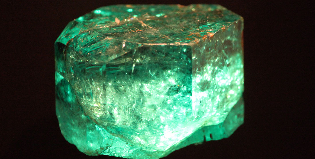 A close up view of an emerald that appears to be glowing