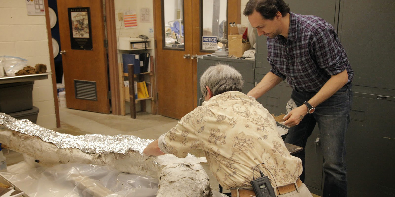 Two researchers cover the mammoth tusk in plaster