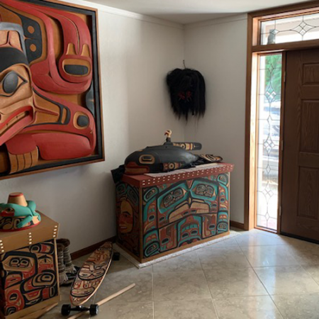 foyer in a home that is filled with large wood carvings created by northwest native artists