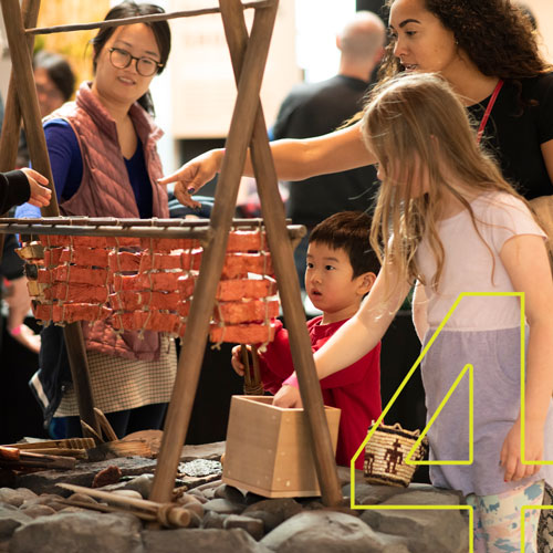 children and adults play with an interactive hearth in the new museum