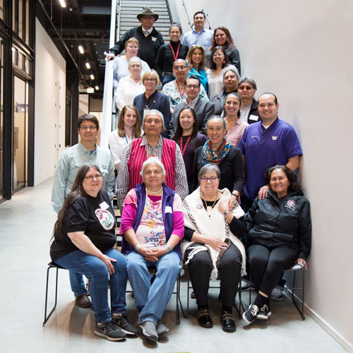 a large group of people stand on a staircase to pose for a photograph