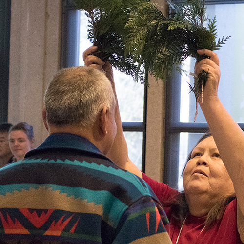 Tribal Elder receives cedar brushing