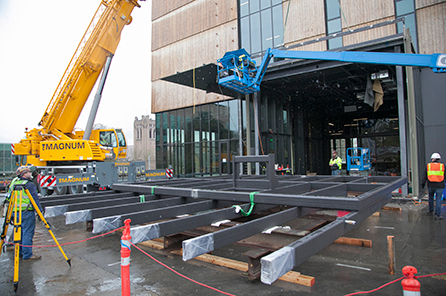 The pivoting window wall being installed by crane