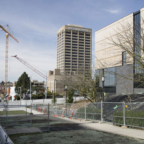 corner of campus with cranes in the background and new burke in the foreground