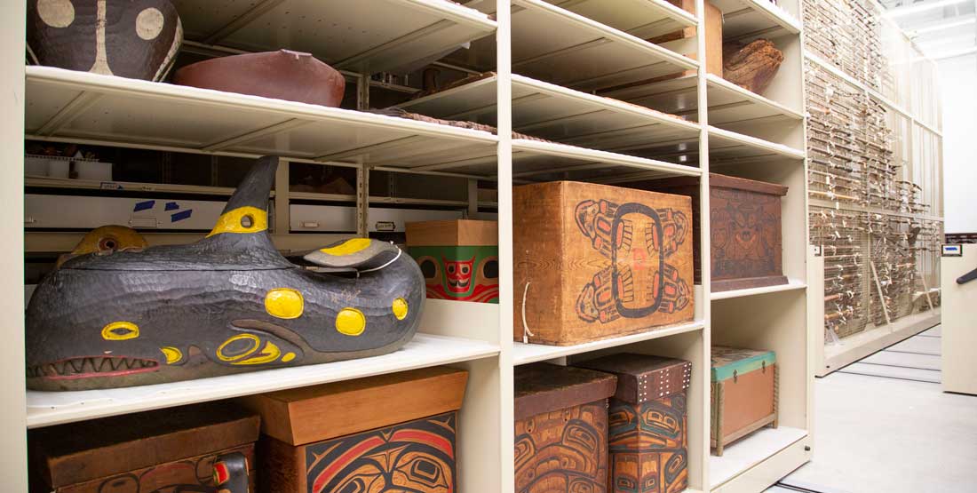 inside the contemporary culture collections storage area, looking at tall shelves filled with large bent wood boxes