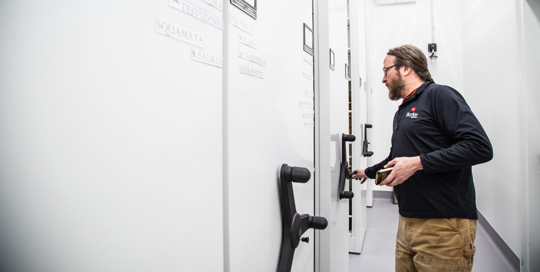 a man turns the compactor wheel to open a row in the collection