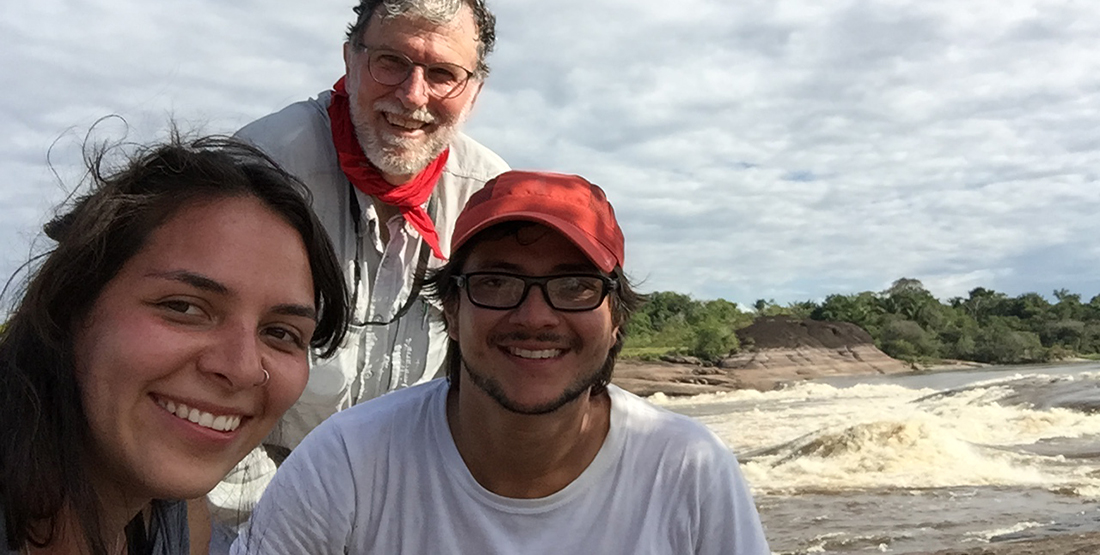 Three researchers posing by the river