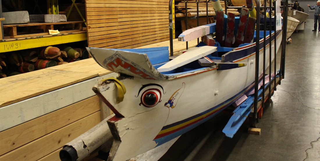 A boat decorated with blue, white and yellow and a painted eye