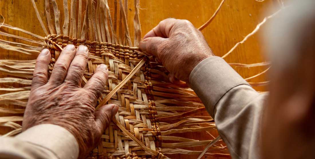 detail of Ed Carriere's hands as he weaves
