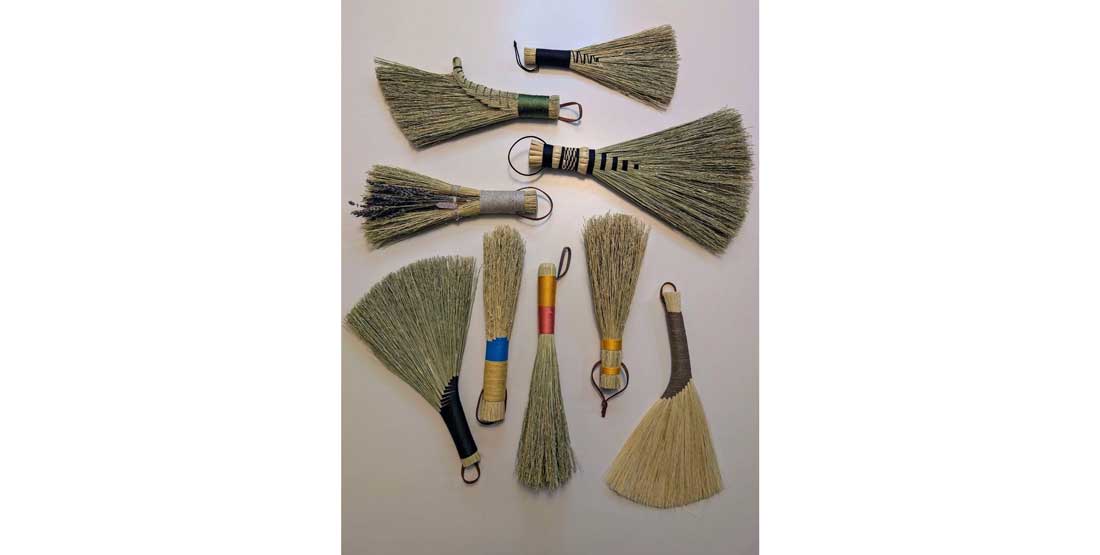 many different traditional brooms with intricate woven patterns