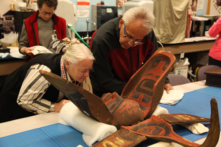 A man and a woman carefully examine the mask in its open position