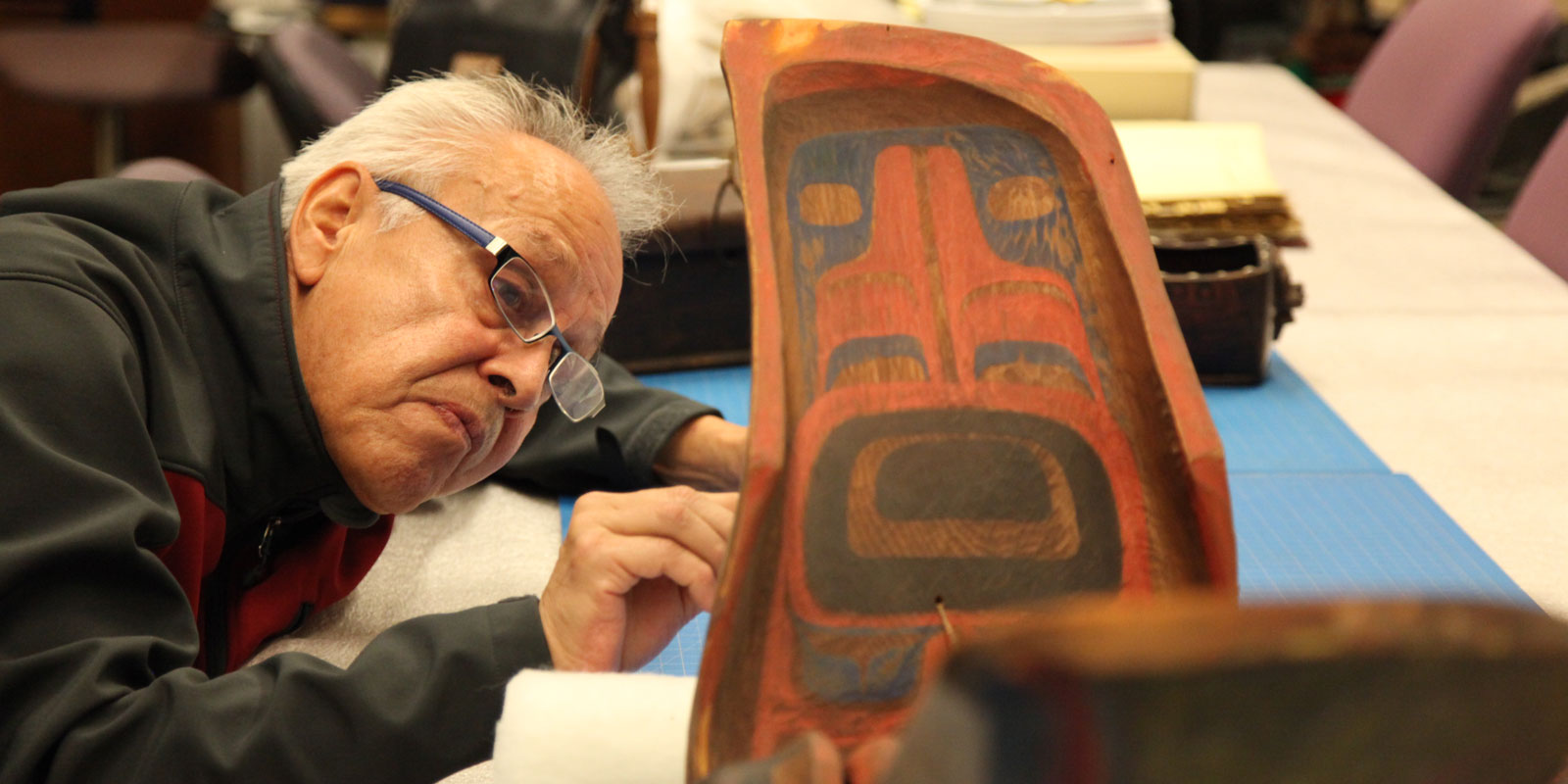 A man carefully examines the mask that likely inspired the Seahawks mask