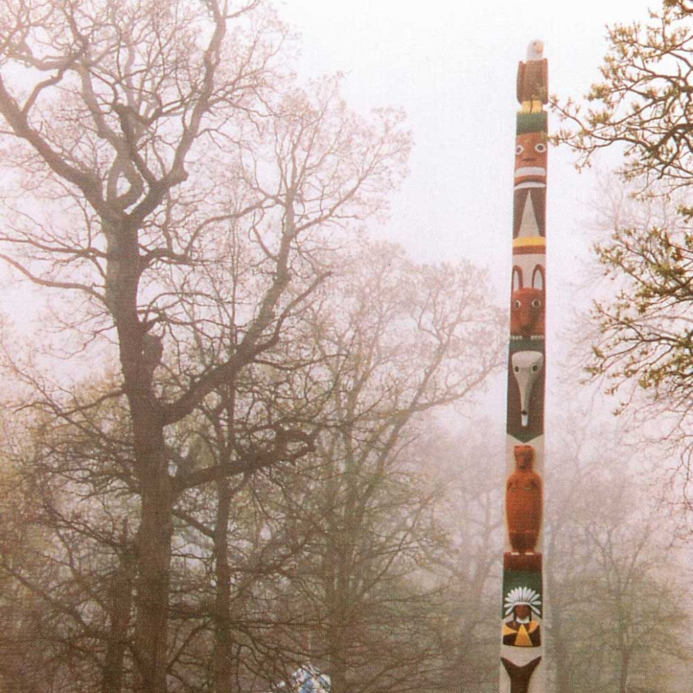 A photograph from the 1970s showing the story pole standing in the park amongst bare trees