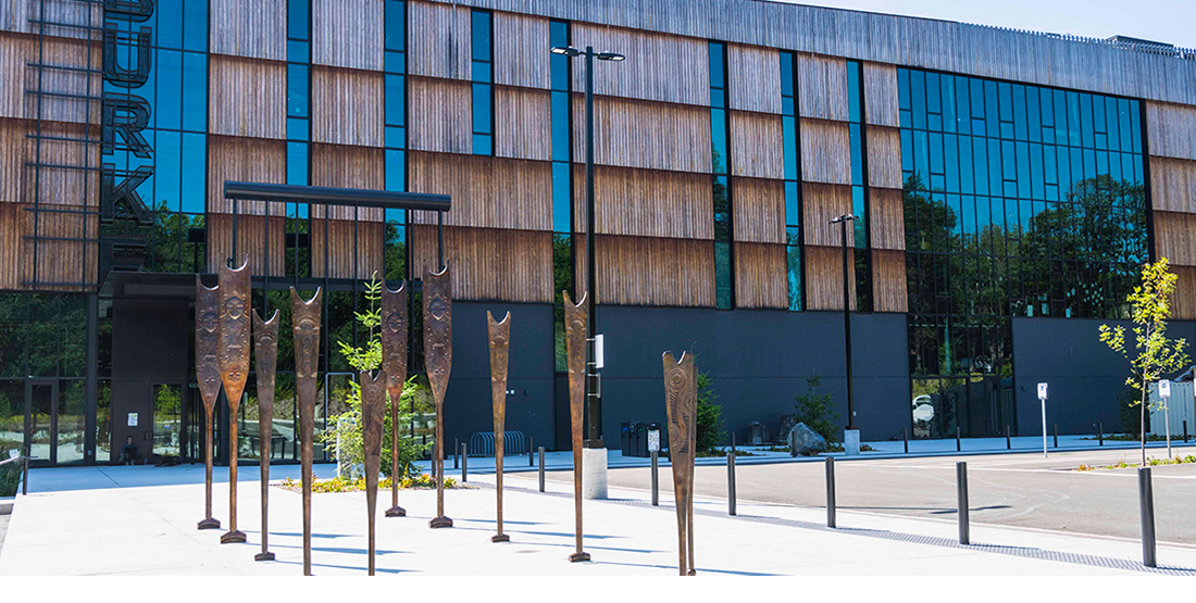 Bronze canoe paddles stand in front of the entrance to the burke museum