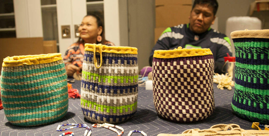 four colorful woven baskets on a table