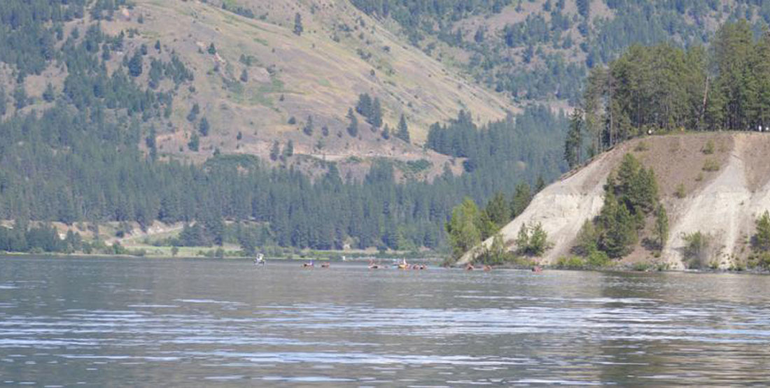 A river with canoes seen paddling in the distance