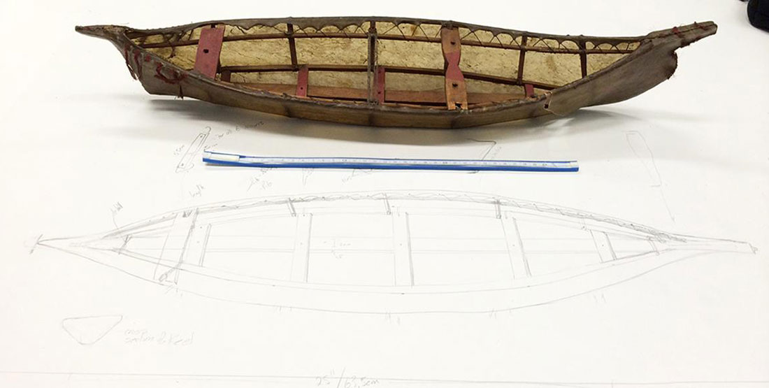 A scale model of the boat next to a pencil sketch of the boat