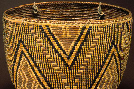 A completed woven basket with black diamond patter