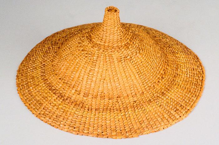 A yellow woven hat with a pointed crown