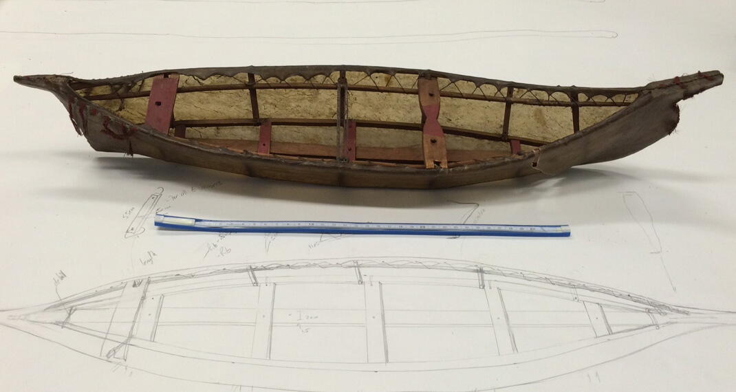 a model angyaaq boat sits on top of a sketch of the model