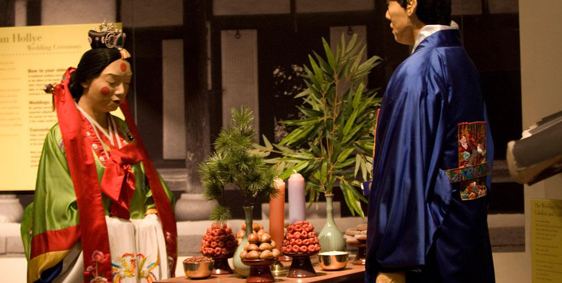 A museum display of a traditional Korean wedding with food on the table