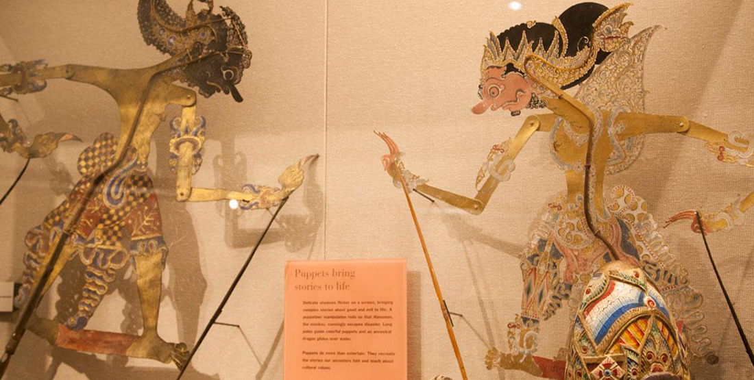 A museum display of two highly-decorated puppets