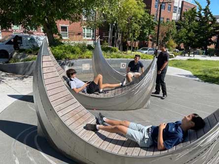 children laying on the metal and wood tatala-inspired benches at Christie Park in seattle