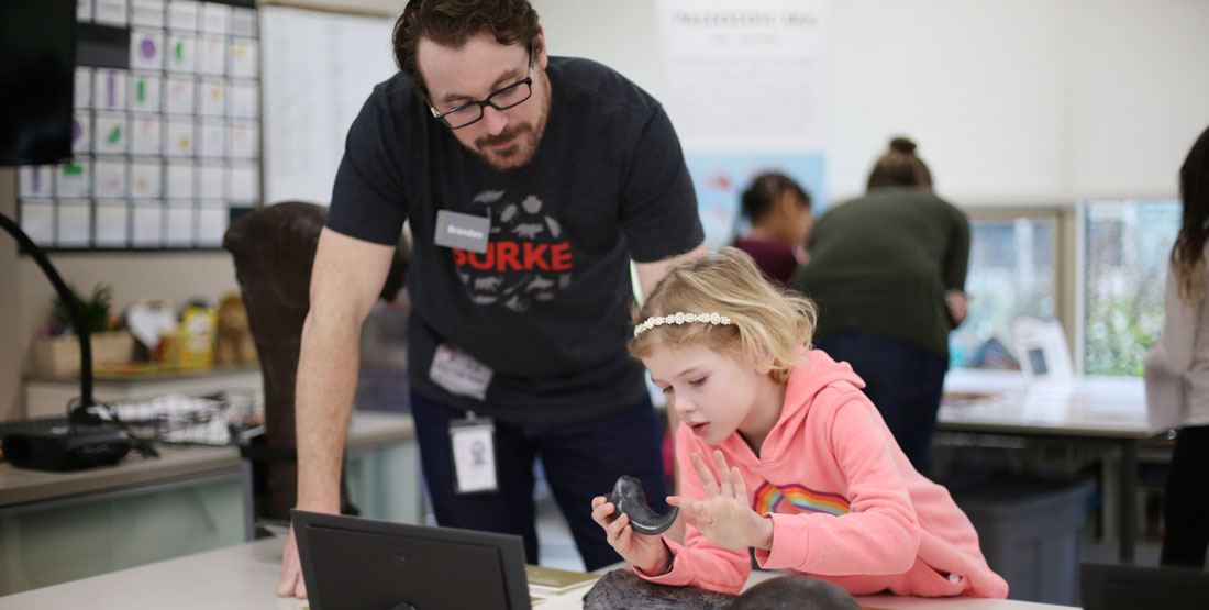 student learns about a cast of a dinosaur claw