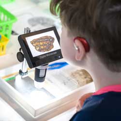 camper looks through a digital microscrop