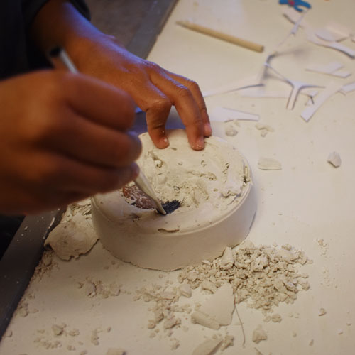 a child excavates a fossil out of plaster