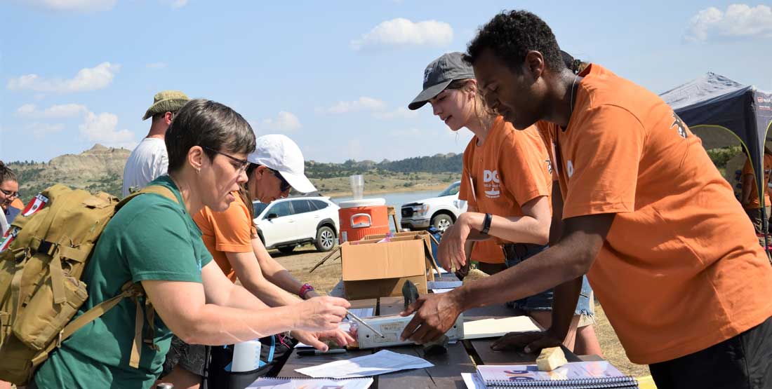 DIG Instructors and volunteers help check in participants and distribute field gear.