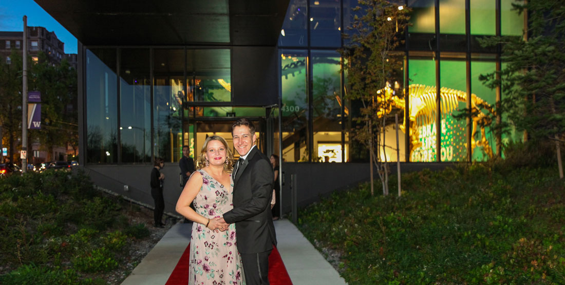 a couple stands in front of the entrance to the grand atrium