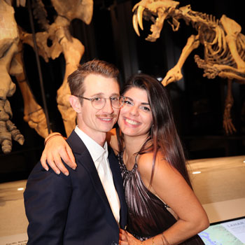 a man and woman pose for the camera in front of fossils gallery