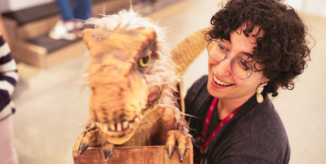 a burke educator with a baby t. rex puppet