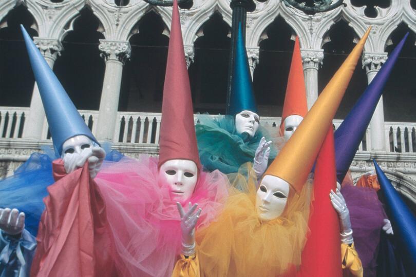 people in masks and hats at a carnaval