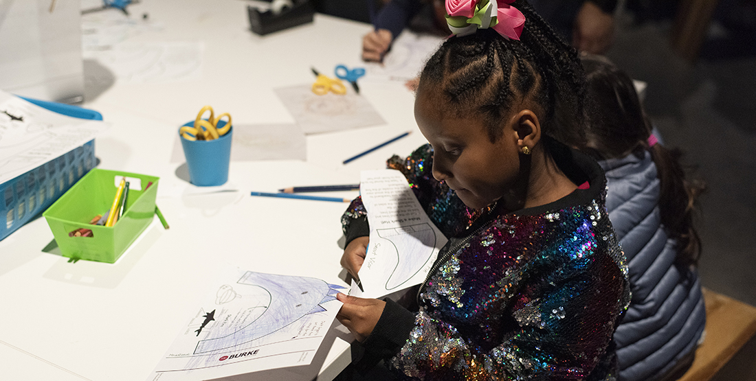 A girl cuts out a craft she colored