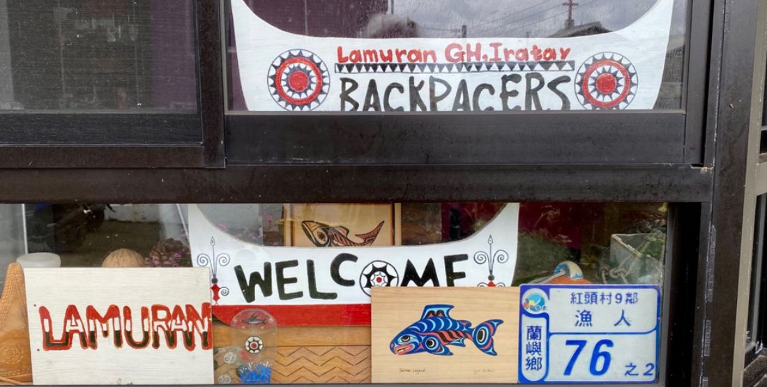 Hand painted signs in a window welcoming backpackers to the town and the hostel.