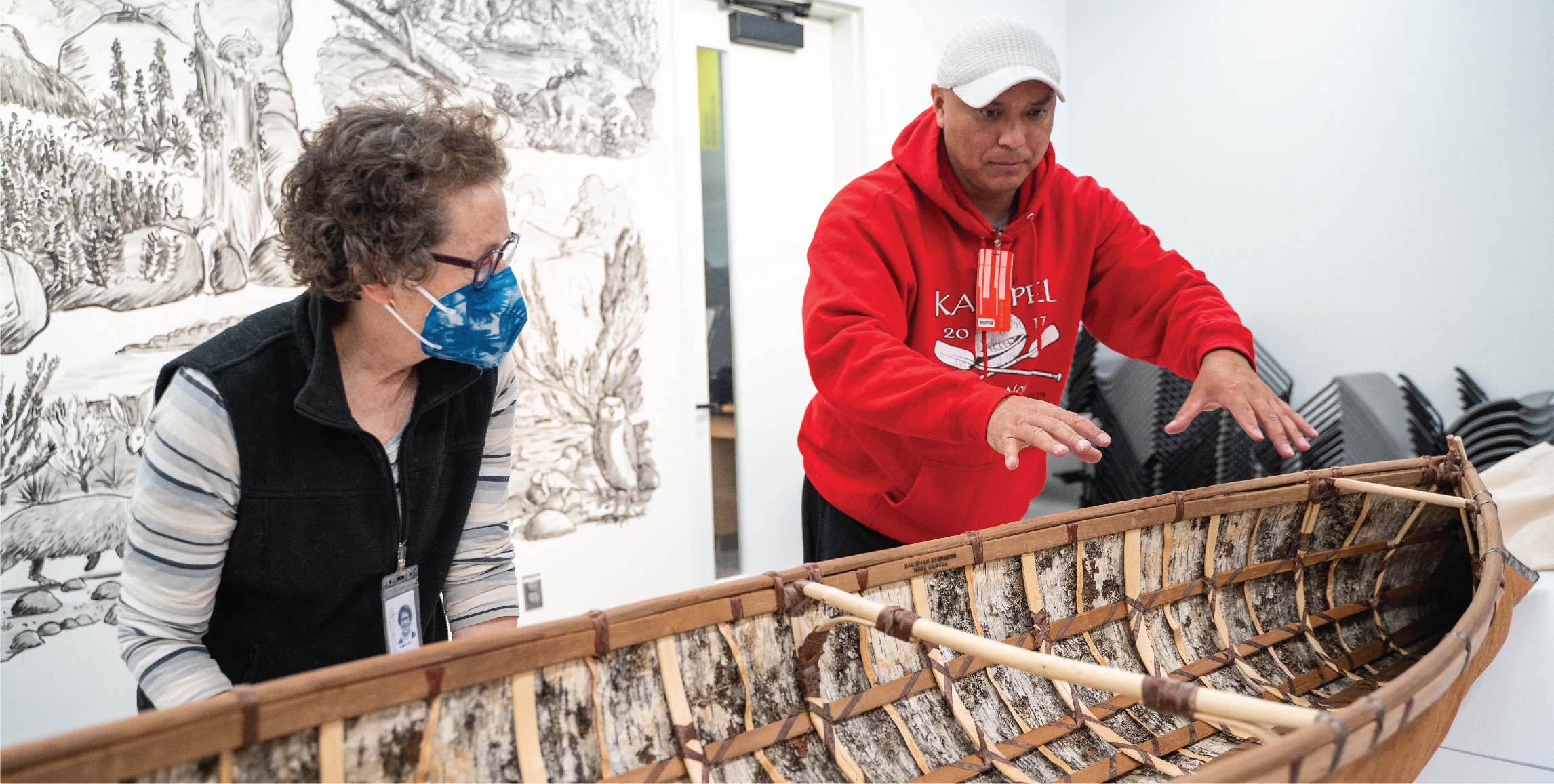 Shawn Brigman explains the details of how he made the canoe to collections manager Rebecca Andrews. 