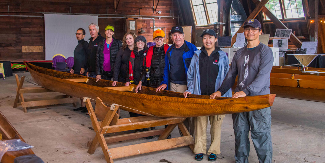 Members of the s.dəxʷìł launch team with the canoe at the ASUW Shell House.