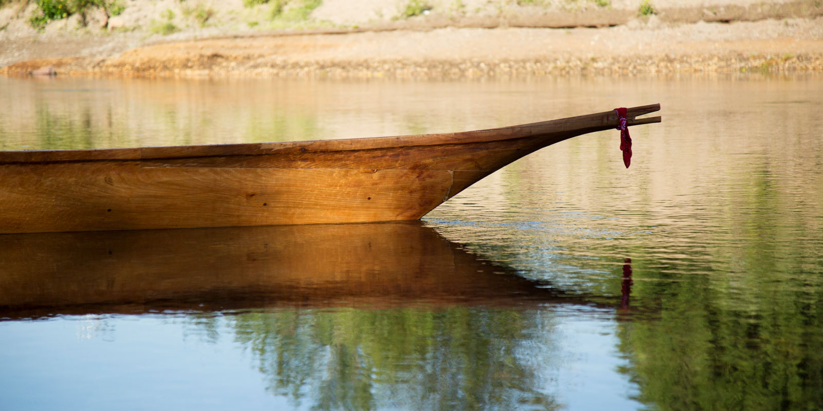close up of the canoe with a bandana tied around its bow