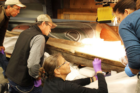 four researchers look closely at the canoe