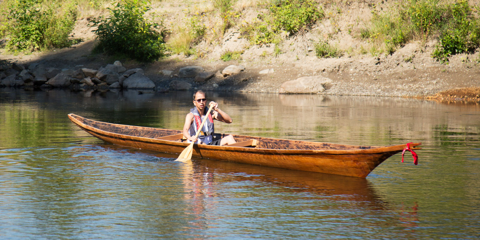 a man paddles the canoe in the green river