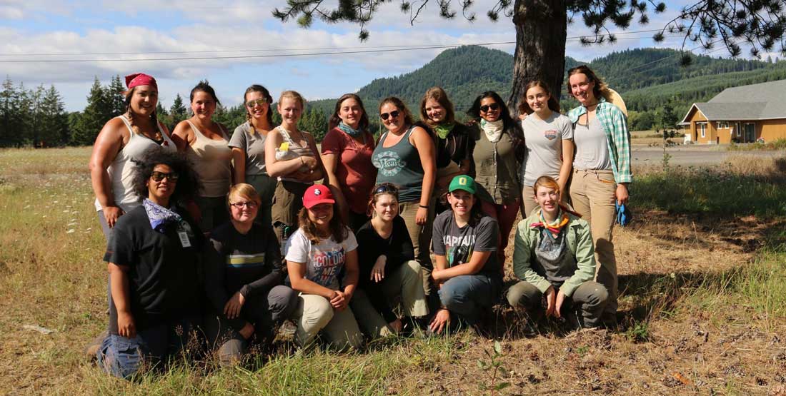 group of archaeologists pose for a group photo in the field