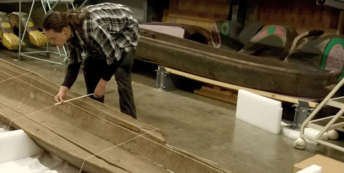 A man lays string to create offset lines for the 3D scan of the canoe