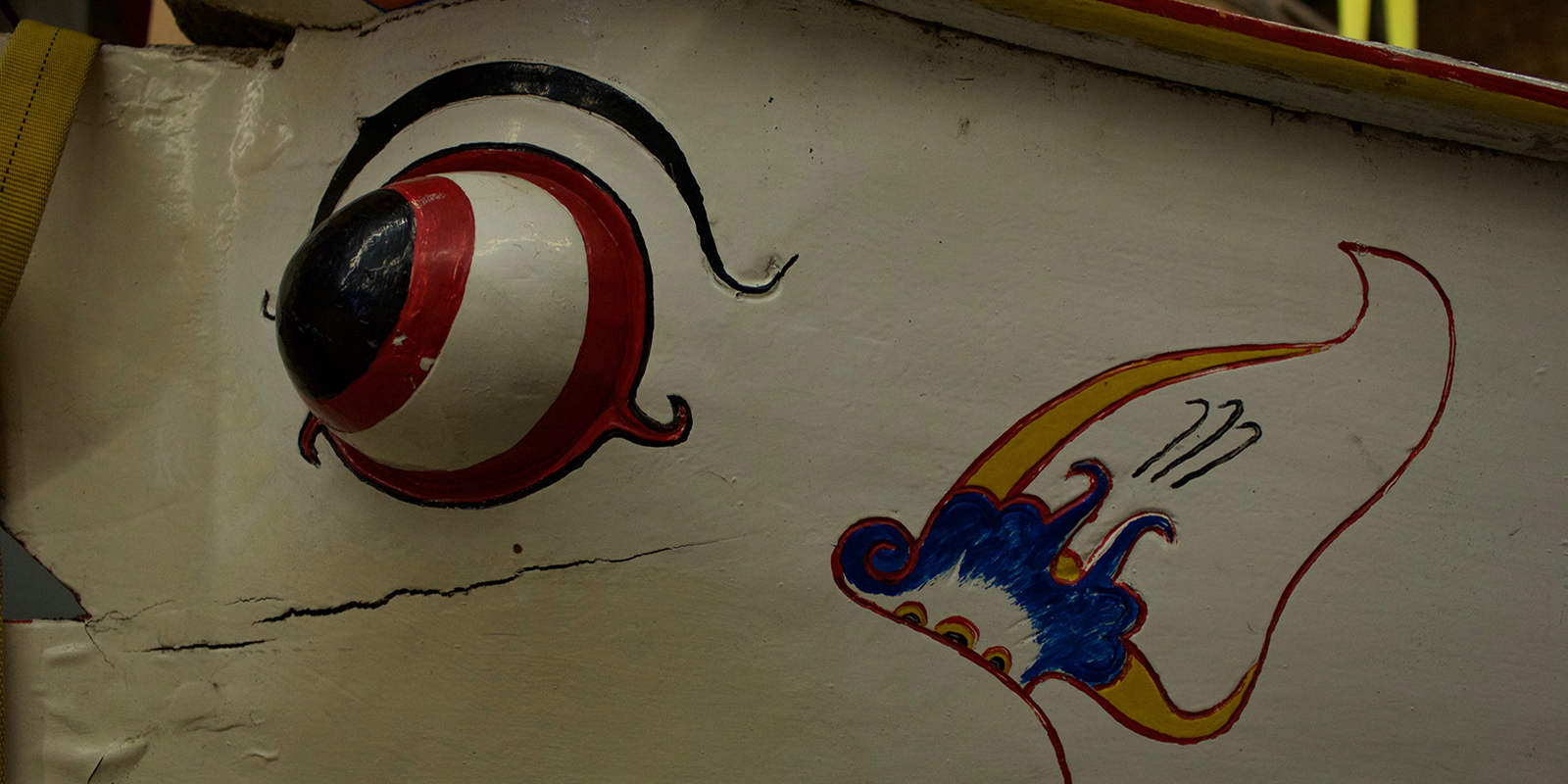 A close up view of the painted eyeball and earings on the boat