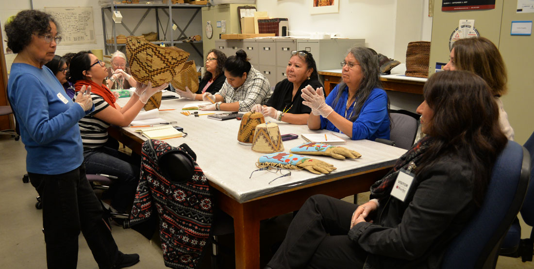a group of women sit around a large table during a basketry workshop